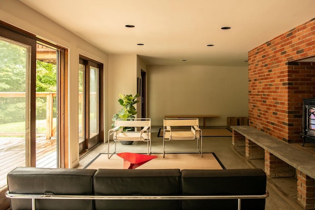 living room featuring brick wall and a wood stove