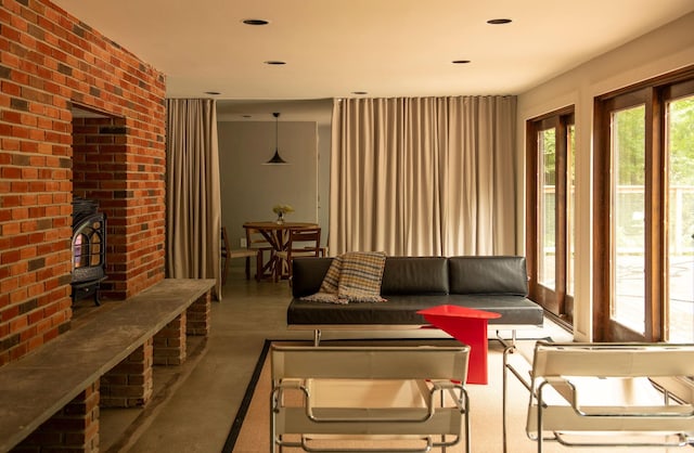 living room featuring brick wall and a wood stove