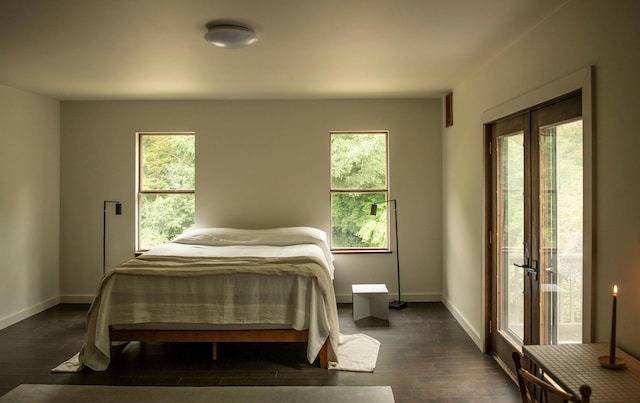 bedroom with multiple windows and dark hardwood / wood-style flooring