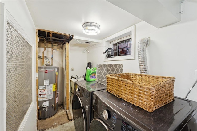 clothes washing area featuring gas water heater and washer and dryer