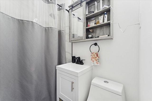 bathroom featuring toilet, curtained shower, and sink