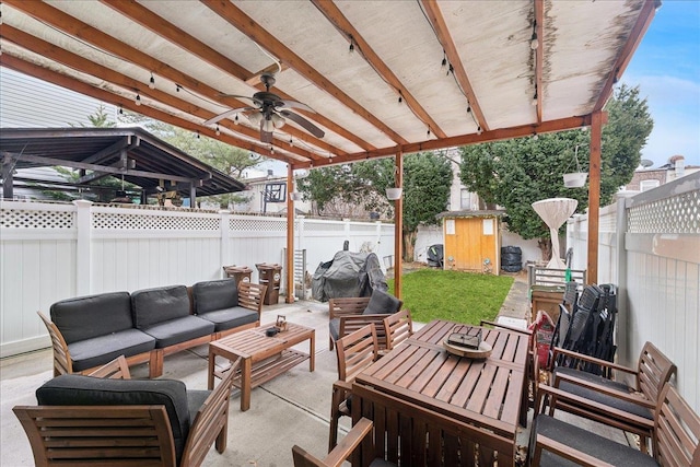 view of patio with a shed, an outdoor living space, and ceiling fan