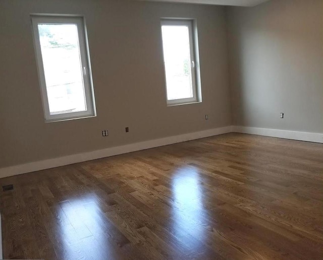 empty room with dark hardwood / wood-style flooring