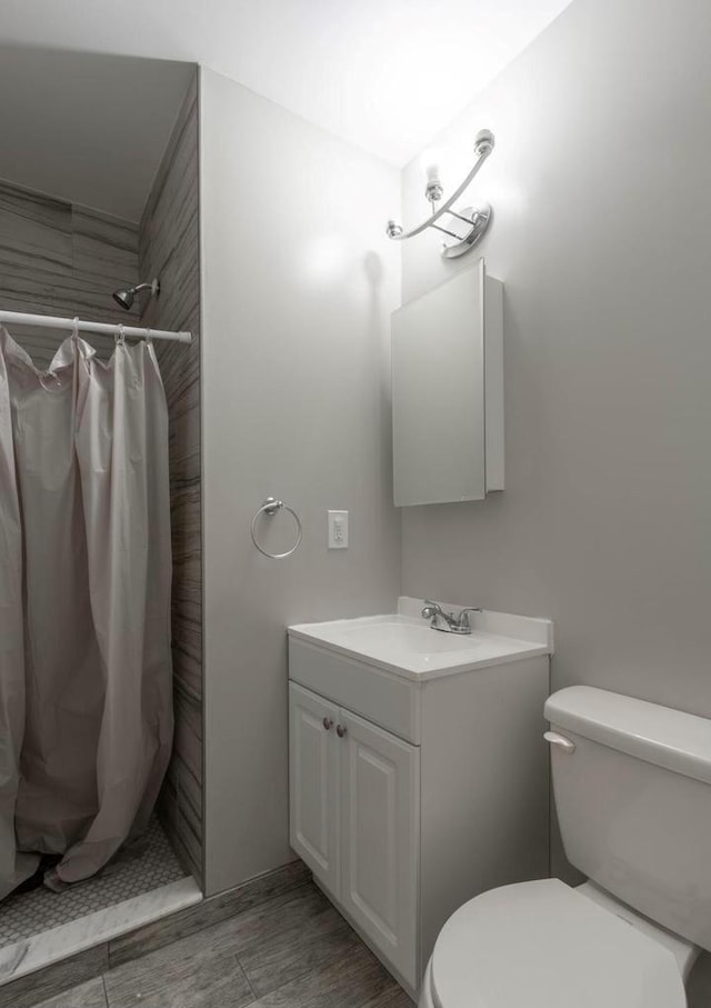 bathroom with vanity, toilet, a shower with shower curtain, and wood-type flooring