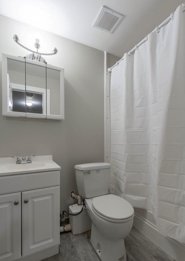 bathroom with vanity, hardwood / wood-style flooring, toilet, and walk in shower