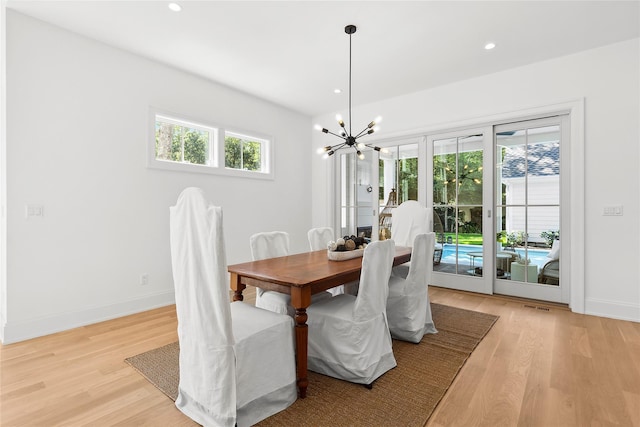 dining space featuring a notable chandelier and light hardwood / wood-style flooring