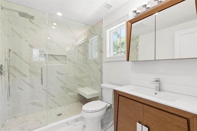 bathroom with a shower with door, vanity, and toilet