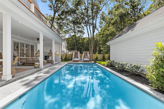 view of pool featuring an outdoor living space, ceiling fan, and a patio area