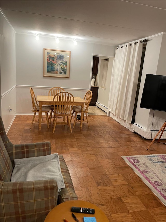 dining space featuring crown molding, parquet flooring, and a baseboard radiator