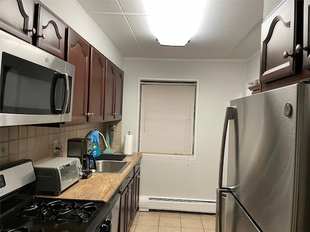 kitchen featuring appliances with stainless steel finishes, sink, light tile patterned floors, baseboard heating, and dark brown cabinets