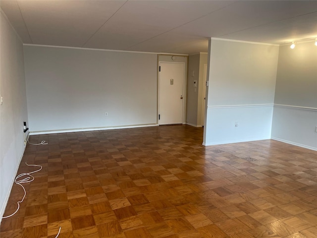 empty room featuring crown molding and dark parquet floors