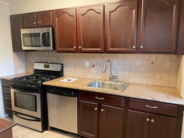 kitchen featuring sink, tasteful backsplash, dark brown cabinets, light tile patterned floors, and appliances with stainless steel finishes