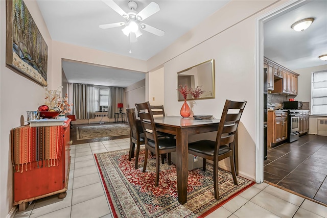 tiled dining room with plenty of natural light and ceiling fan