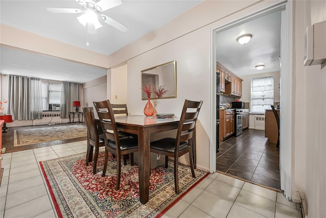 dining area featuring radiator, ceiling fan, a healthy amount of sunlight, and light tile patterned flooring