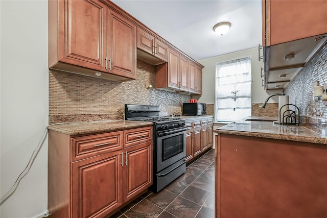 kitchen featuring sink, dark tile patterned floors, backsplash, stainless steel range with gas stovetop, and light stone countertops