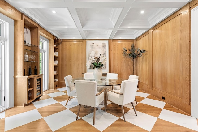 dining room with ornamental molding, coffered ceiling, beam ceiling, and wood walls