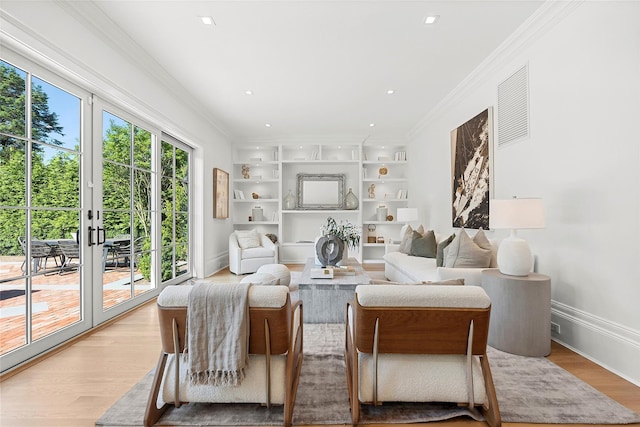 living room featuring french doors, built in features, ornamental molding, and light hardwood / wood-style flooring