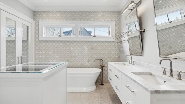 bathroom featuring vanity, ornamental molding, a tub, and tile walls