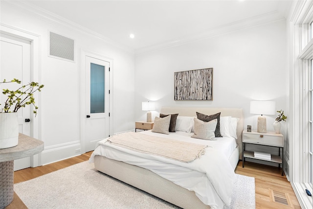 bedroom featuring ornamental molding and light hardwood / wood-style floors