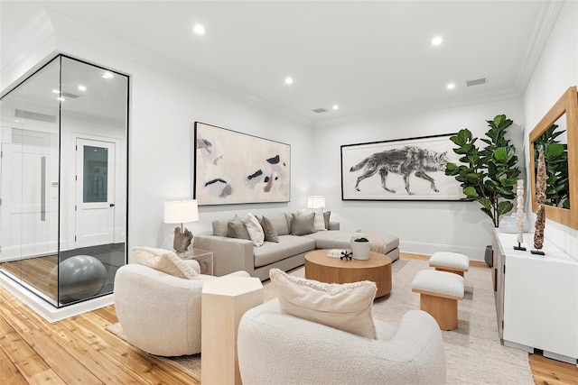 living room with ornamental molding and light hardwood / wood-style floors