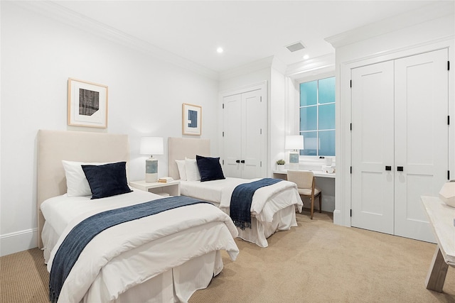 bedroom featuring two closets, built in desk, ornamental molding, and light colored carpet