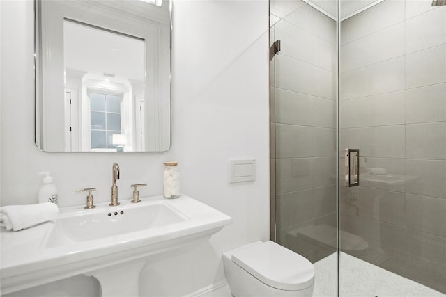 bathroom featuring toilet and a shower with door