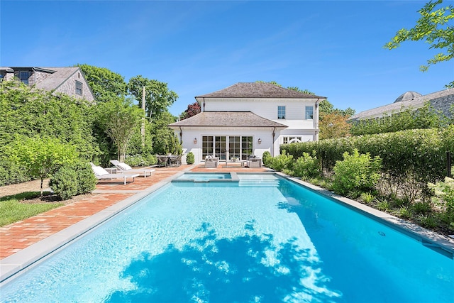 view of swimming pool with an outdoor structure and a patio area