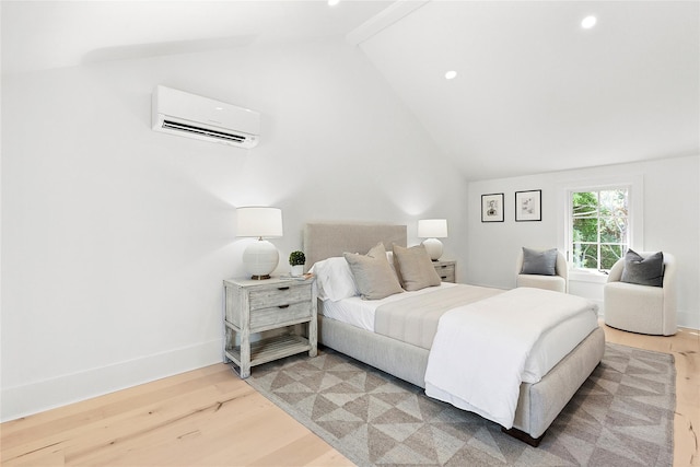 bedroom featuring hardwood / wood-style flooring, vaulted ceiling, and a wall mounted AC