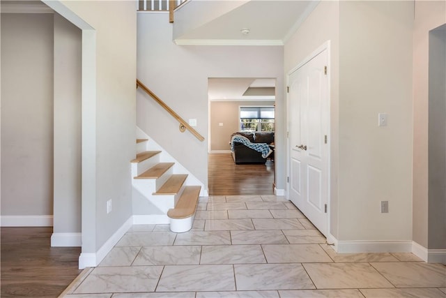 entrance foyer featuring ornamental molding and light hardwood / wood-style floors