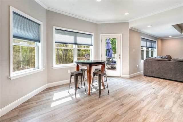 dining space featuring crown molding and light wood-type flooring