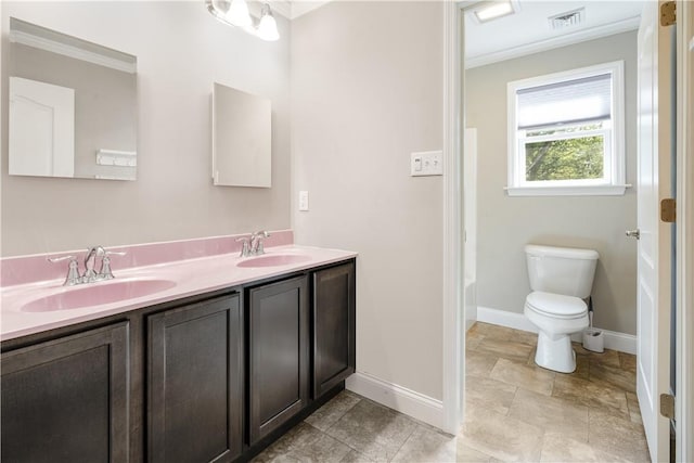 bathroom with vanity, crown molding, and toilet