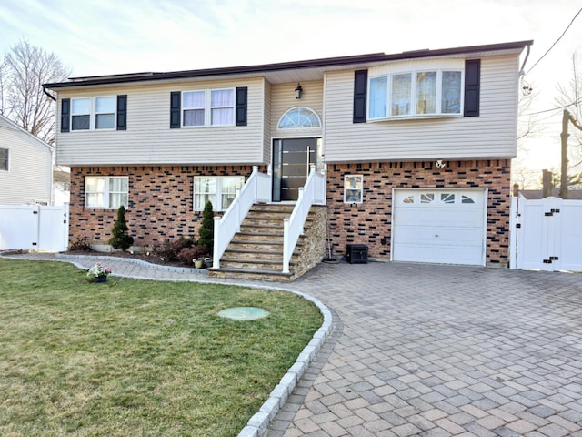 raised ranch featuring a garage and a front lawn