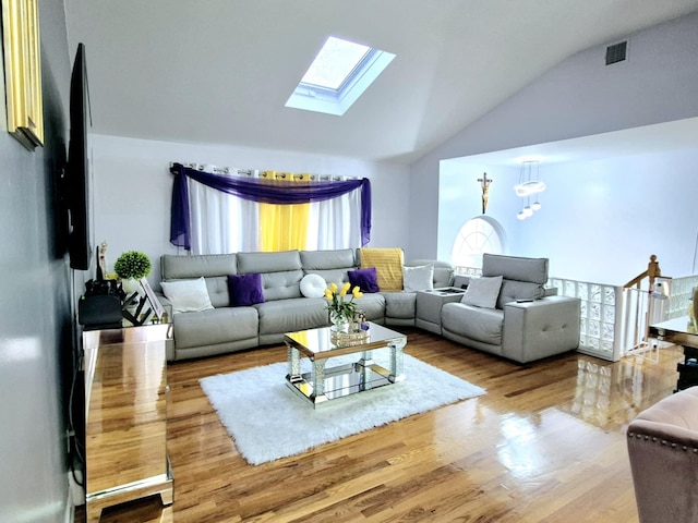 living room with wood-type flooring and lofted ceiling with skylight