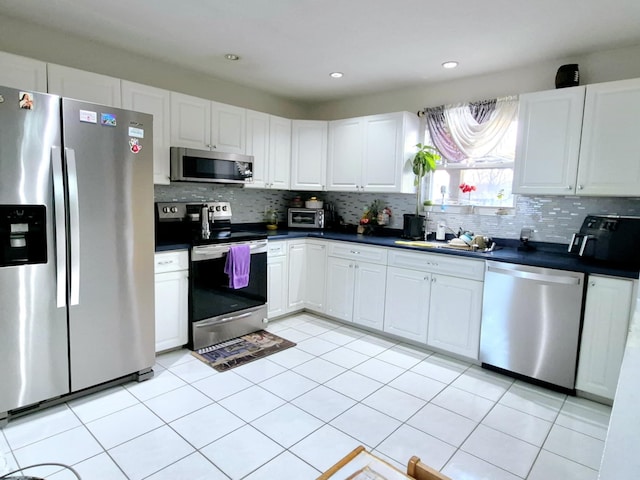 kitchen featuring white cabinetry, stainless steel appliances, sink, and decorative backsplash