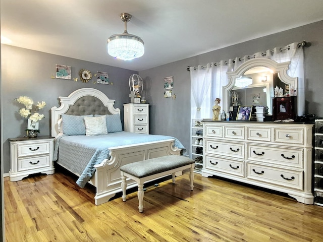 bedroom featuring a chandelier and light hardwood / wood-style flooring