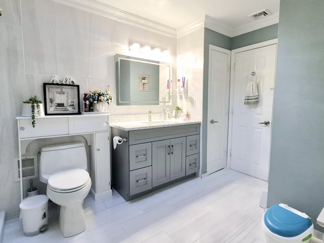 bathroom with ornamental molding, vanity, and toilet