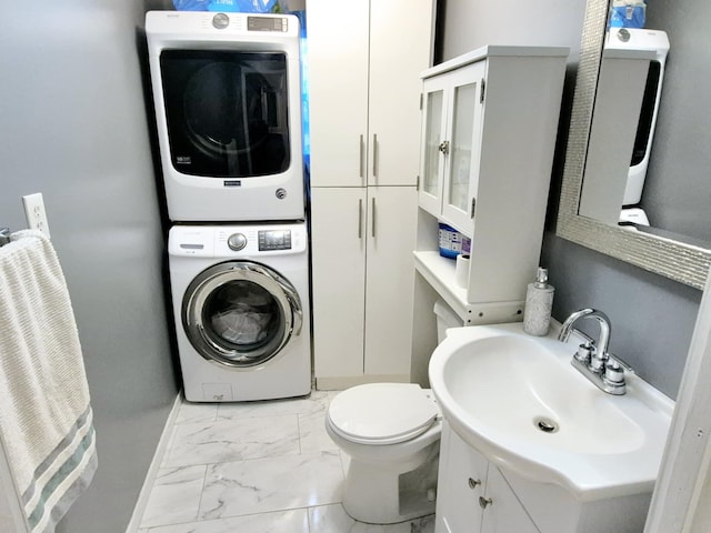 bathroom with stacked washing maching and dryer, vanity, and toilet