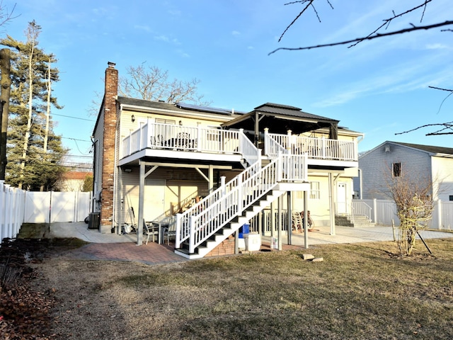 back of property with a patio area, a lawn, and a deck