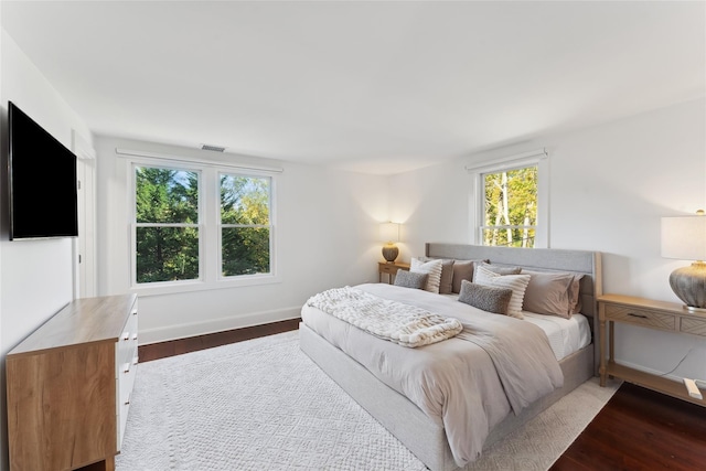 bedroom featuring visible vents, baseboards, and wood finished floors