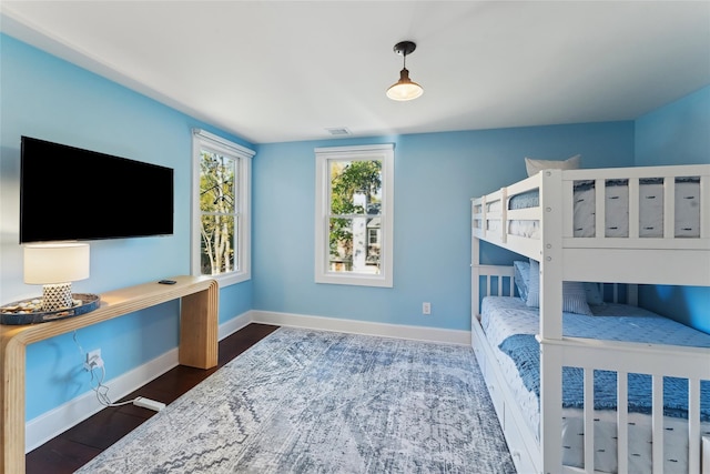 bedroom featuring wood finished floors, visible vents, and baseboards