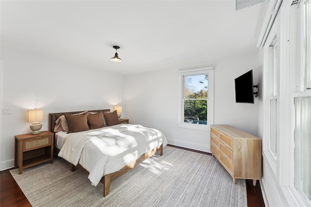 bedroom with light wood-style flooring, visible vents, and baseboards