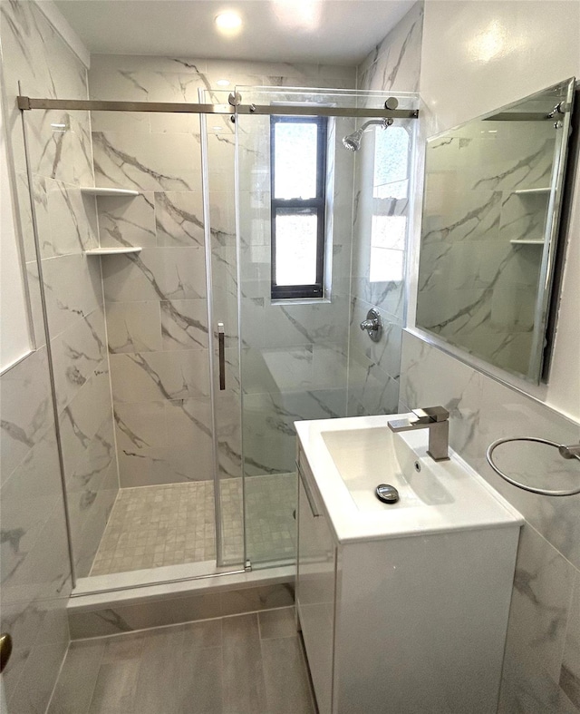 bathroom featuring vanity, tile walls, and an enclosed shower