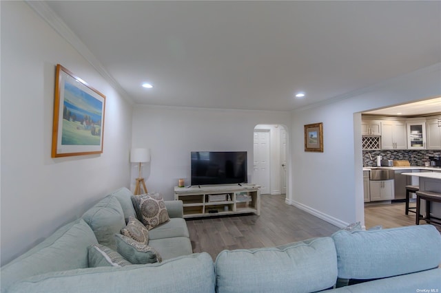 living room with ornamental molding and light hardwood / wood-style floors