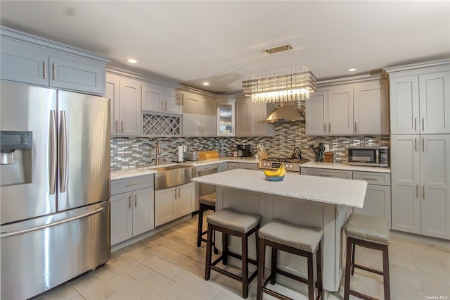 kitchen with a kitchen island, appliances with stainless steel finishes, decorative light fixtures, sink, and a kitchen breakfast bar