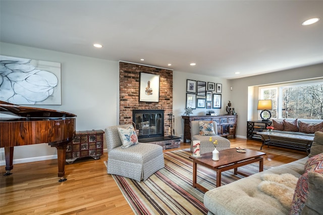 living room with a fireplace and light wood-type flooring