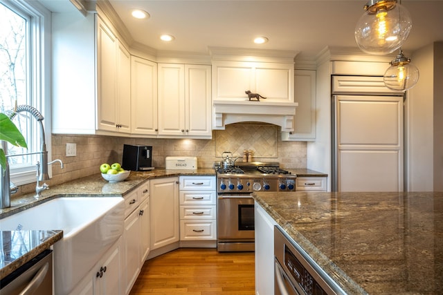 kitchen featuring white cabinetry, hanging light fixtures, stainless steel appliances, and sink