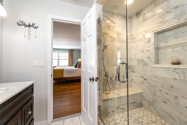 bathroom featuring hardwood / wood-style flooring, vanity, and a shower with shower door