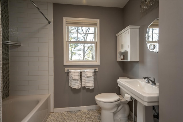 bathroom featuring tiled shower / bath, toilet, and tile patterned flooring