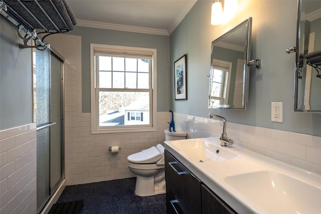 bathroom featuring ornamental molding, toilet, tile walls, and a shower with shower door