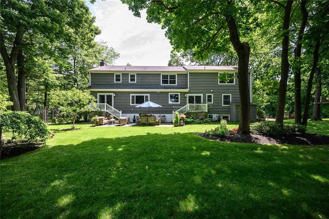 rear view of property featuring a lawn